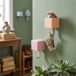 Four colorful adhesive cat wall hooks in pastel boxes with kittens popping their heads out to hold keys and coats on a modern wall.