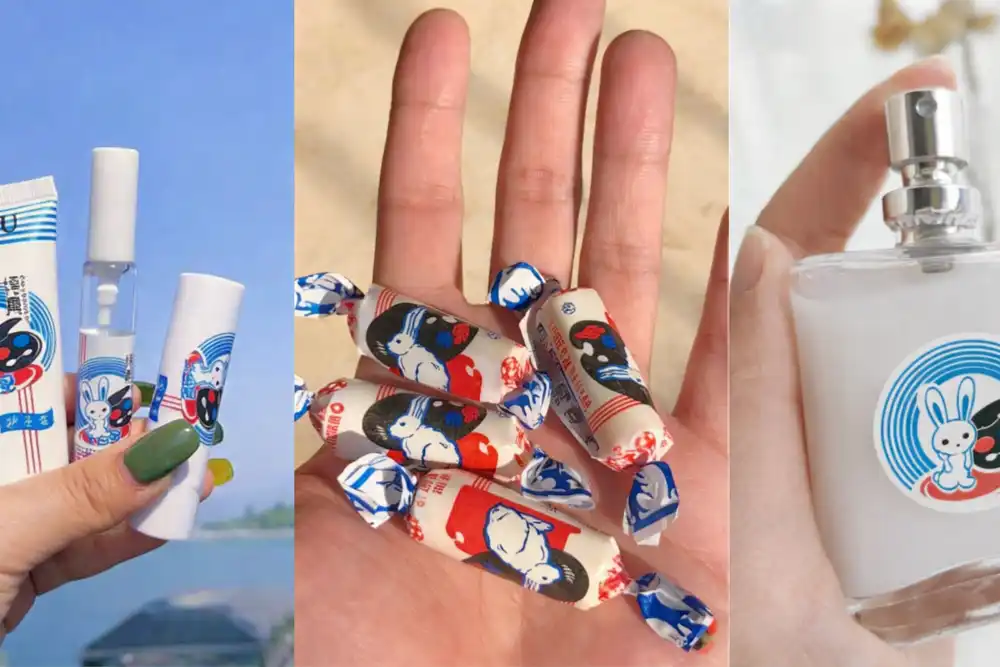 A close-up of the White Rabbit milk candy perfume bottle featuring a cartoon rabbit logo with a black mask and blue-red-white circular design, held in hand beside matching candy and cosmetic packaging that share the same playful branding theme.